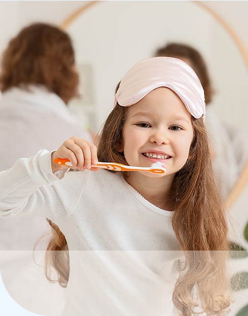 a girl with a pink eye mask holding a toothbrush